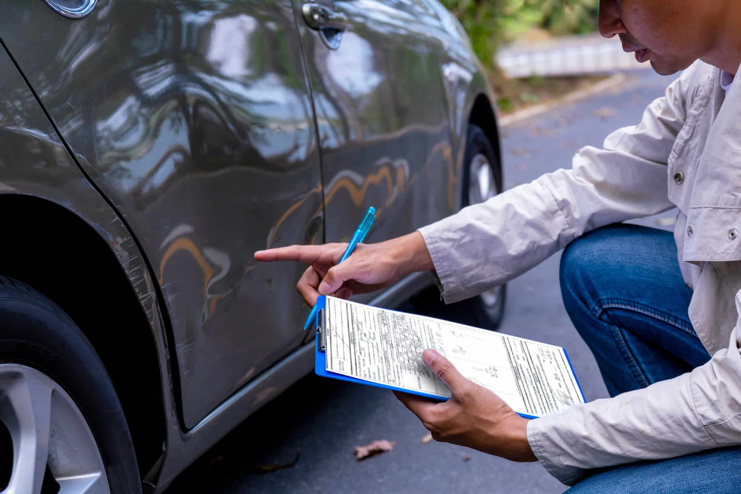insurance adjuster examining car damage