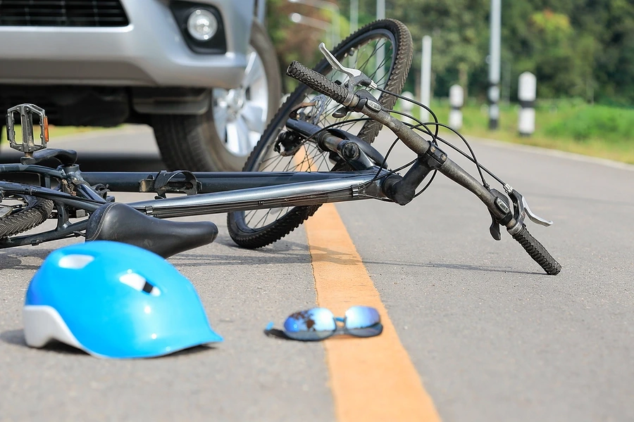 Bicycle knocked down by vehicle with helmet on road